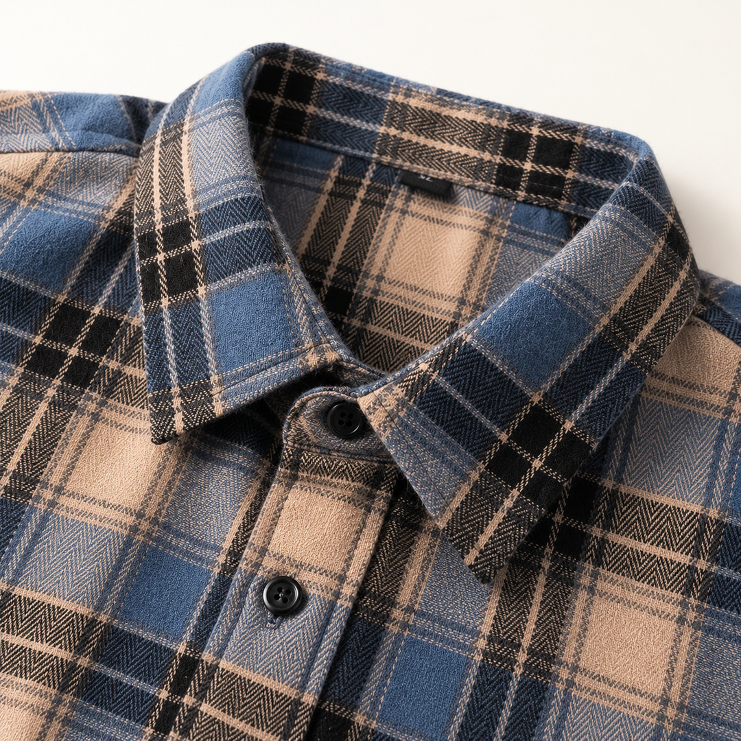 Close-up of the blue and beige plaid flannel collar, woven texture and black buttons.