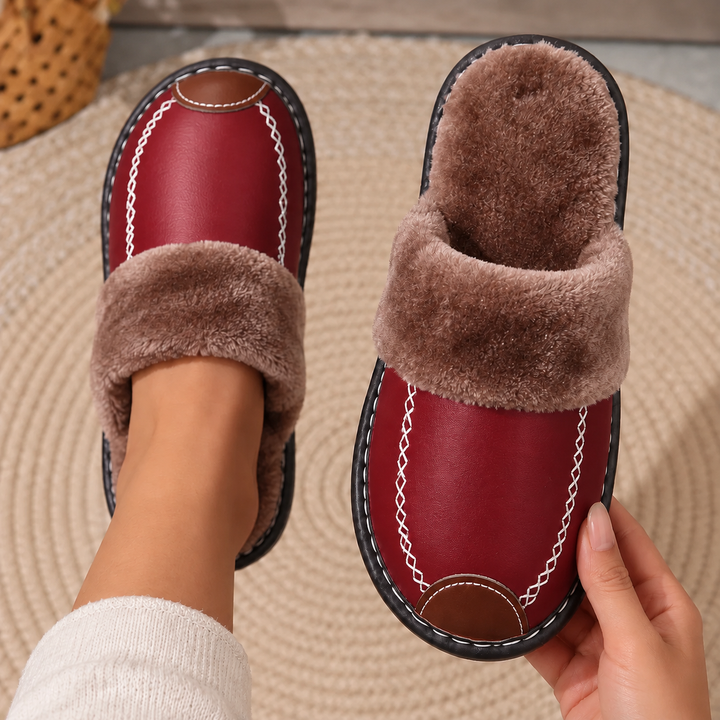 Laurel Fur-Lined Slippers in Burgundy, worn and held above a woven rug